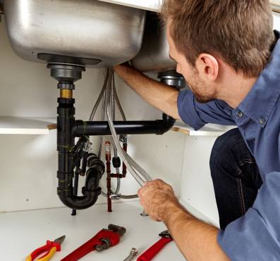 Expert plumber repairing and replacing a tap in a sink to improve water flow and prevent leaks